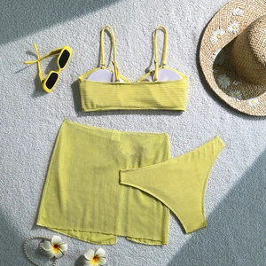 Detailed texture of yellow waffle knit three-piece bikini set with matching beach skirt