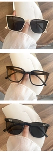 Detail of oversized square sunglasses featuring chic metal EB logo on the temples