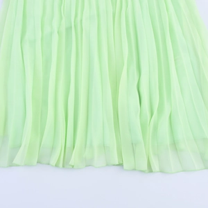 Elegant light green pleated maxi skirt with a flowy hemline for a minimalist vacation look