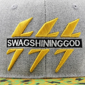 Close-up of Swagshininggod embroidery and yellow lightning patterns on gray fabric