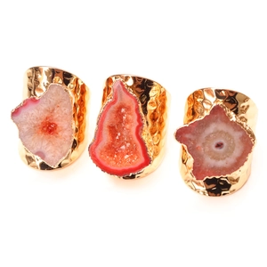 Close-up of gold-plated hammered rings with pink natural agate crystal druzy slices