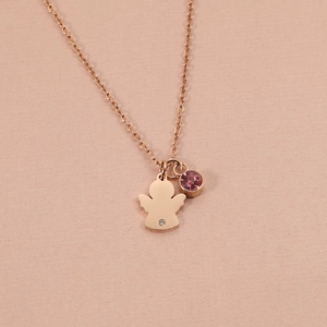 Close-up of rose gold angel pendant with pink birthstone and clear crystal on fabric