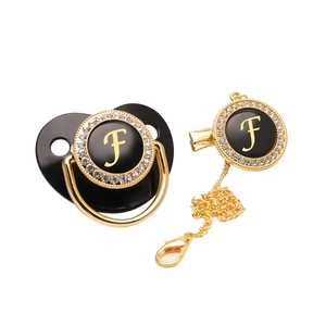Luxurious black and gold baby pacifier set with letter F and rhinestone accents