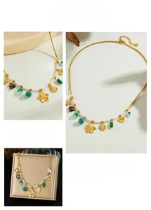 Close-up of gold stainless steel necklace with camellia charms, pearls and heart pendants