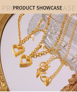 Détail du collier coeur doré avec perle et fermoir rose sur une surface en miroir