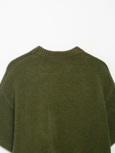 Gros plan sur le col rond côtelé et la texture en maille fine de ce pull vert olive