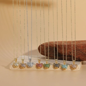 Detailed close-up of bear-shaped pendants with colorful zircons on beige stone surface