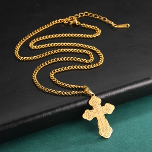 Detailed macro view of the gold Orthodox cross pendant with Jesus Christ engraving