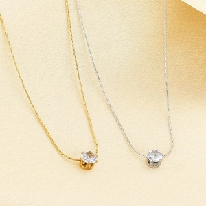 Détail de colliers en acier inoxydable or et argent avec pendentifs en zircon rond