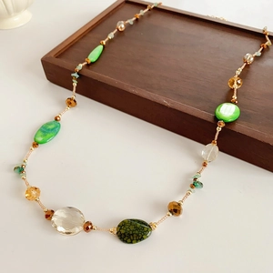 Detailed shot of bohemian long beaded necklace with green agate and glass beads