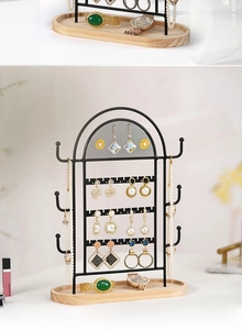 Detail of black metal grid jewelry organizer with a wooden base for earrings and necklaces