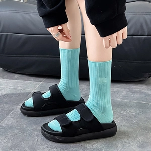 Sandales à plateforme noires avec chaussettes mi-mollet en coton côtelé bleu menthe