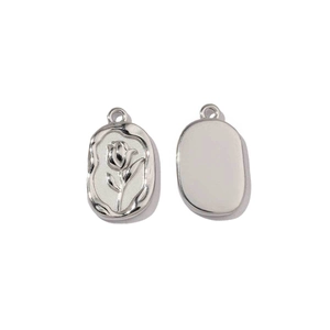 Detailed macro view of mirror polished silver oval pendant with rose engraving and plain finish
