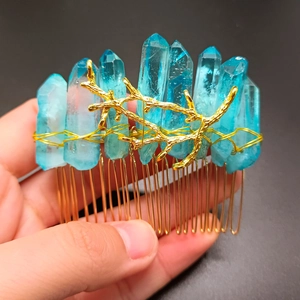 Detail eines handgefertigten Haarkamms mit goldenen Zweigen und blauen Kristallen