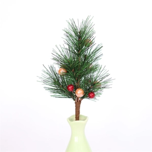 Détail de branches de pin artificiel avec boules rouges scintillantes et ornements champagne