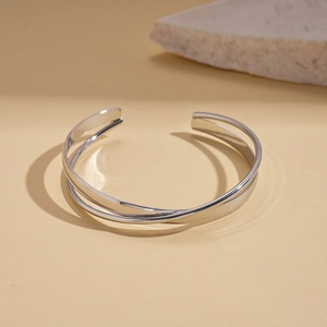 Detailed shot of a silver double-layered open bangle with a polished metallic finish