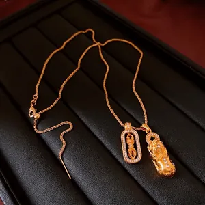 Luxurious gold necklace with zircon PiXiu and Vajra pendants on black leather background