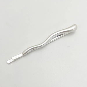 Detail of silver wavy irregular metal hair clip on a clean white background