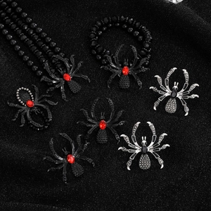 Macro detail of gothic spider jewelry set with red crystals and black beaded chains