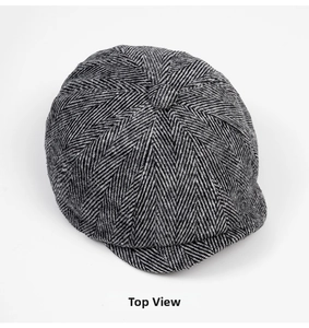 Top view of classic grey herringbone newsboy cap made of thick tweed wool fabric