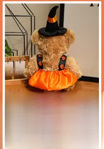Detail of Halloween witch bear plush toy with pointed hat and pumpkin pattern dress