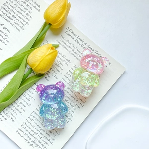 Détail de supports de téléphone ours en résine à paillettes dégradé rose et violet