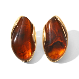Close-up of vintage irregular amber resin stud earrings with elegant gold plating