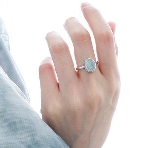 Detail of 925 sterling silver ring with oval light blue crystal on model's finger