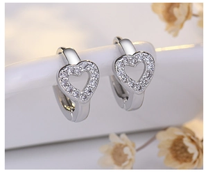 Macro shot of silver heart-shaped hoop earrings with micro-inlaid sparkling zircon stones
