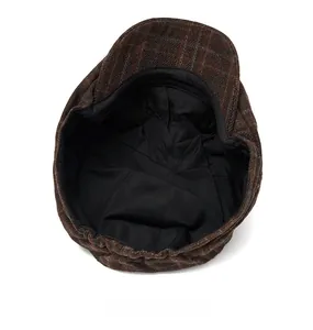 Detailed interior of vintage newsboy cap with black fabric lining and plaid pattern