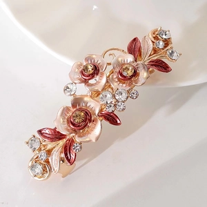 Détail du clip à cheveux floral doré avec roses en émail et strass brillants élégants