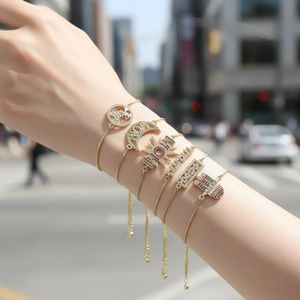 Detailed close-up of six gold adjustable bracelets with colorful zircon charms on a wrist