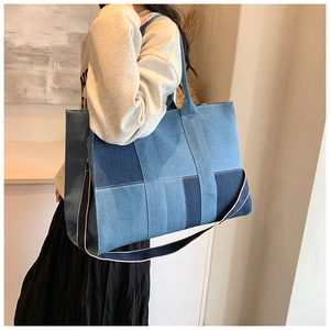 Detail of patchwork denim tote bag showing multi-tone blue layers and durable stitching