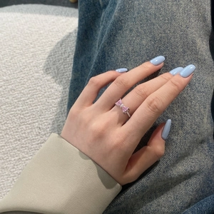 Gros plan d'une bague nœud avec pierres roses en cœur et cristaux micro-pavés
