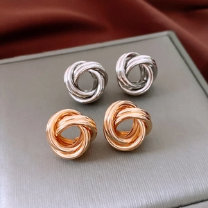Vue détaillée de boucles d'oreilles nœuds d'amour en argent et or sur velours