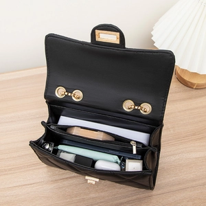 Black quilted crossbody bag with gold hardware showing interior compartments and essentials