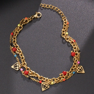 Detail of a double-layered gold chain with colorful beads and triangle diamond pendants
