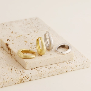 Macro shot of S925 sterling silver earrings with brushed texture on stone pedestal