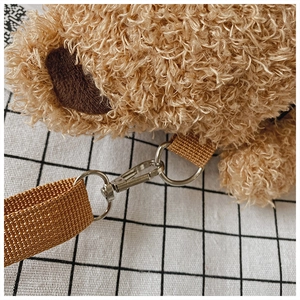 Close-up of the shoulder strap connection on a brown plush teddy bear crossbody bag