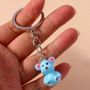 Close-up of a blue resin bear keychain with pink ears and silver metal ring accessory