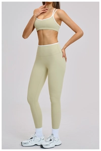 Dettaglio del set yoga verde salvia con bordi a contrasto bianchi su reggiseno e legging