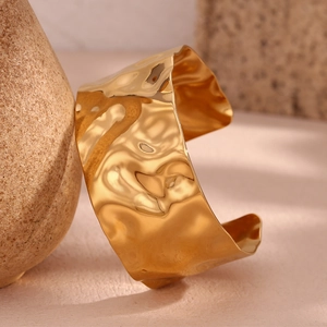Macro shot of 18K gold plated stainless steel cuff with hammered texture details