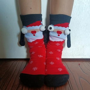 Detail of red Christmas magnetic socks featuring 3D Santa Claus and snowflake knit pattern