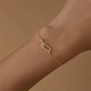 Close-up of interlocking geometric gold bracelet with pavé crystals on wrist