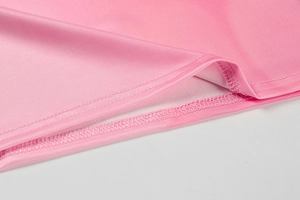 Macro detail of high-quality double-stitched hem on a pink summer tube top garment