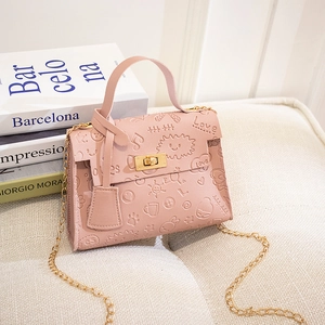 Pink embossed cartoon handbag with gold chain strap and sun patterns in a soft setting