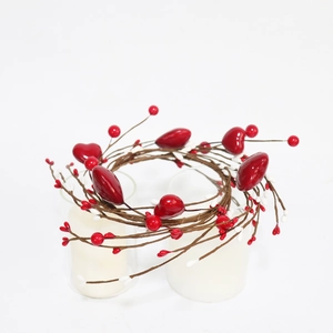 Close-up of red heart berry candle ring with brown branches for table decoration