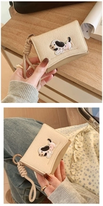 Close-up of beige canvas wallet with cute puppy embroidery and matching wrist strap