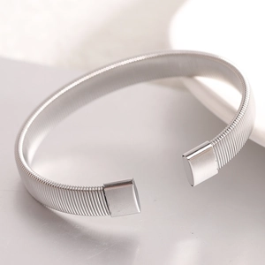 Detailed macro view of silver stainless steel flexible wire cuff bracelet with metal caps