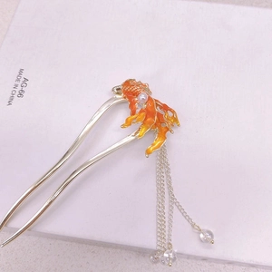 Detailed view of U-shaped hair stick with orange koi fish charm and silver tassels